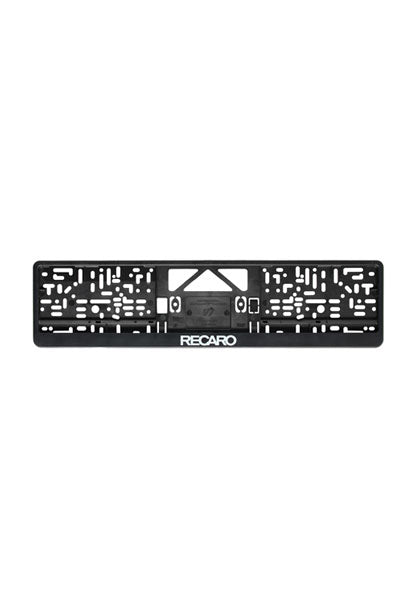Eine schwarze Kennzeichenhalterung aus Polypropylen (2er Set) von Recaro_Merch_Daniel, mit diversen Schlitzen und Aussparungen und dem weißen RECARO Logo unten mittig.