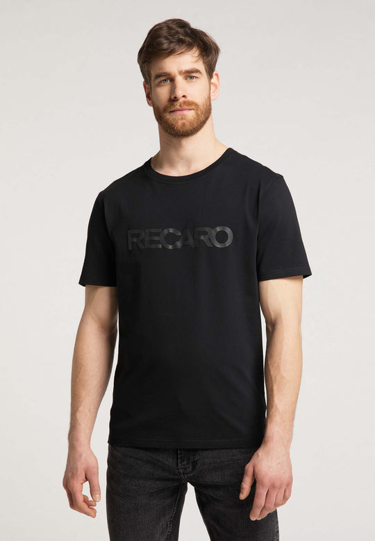 Ein Mann mit kurzen braunen Haaren und Bart trägt ein T-Shirt Originals RECARO von Recaro_Merch_Daniel und steht vor einem schlichten hellen Hintergrund.