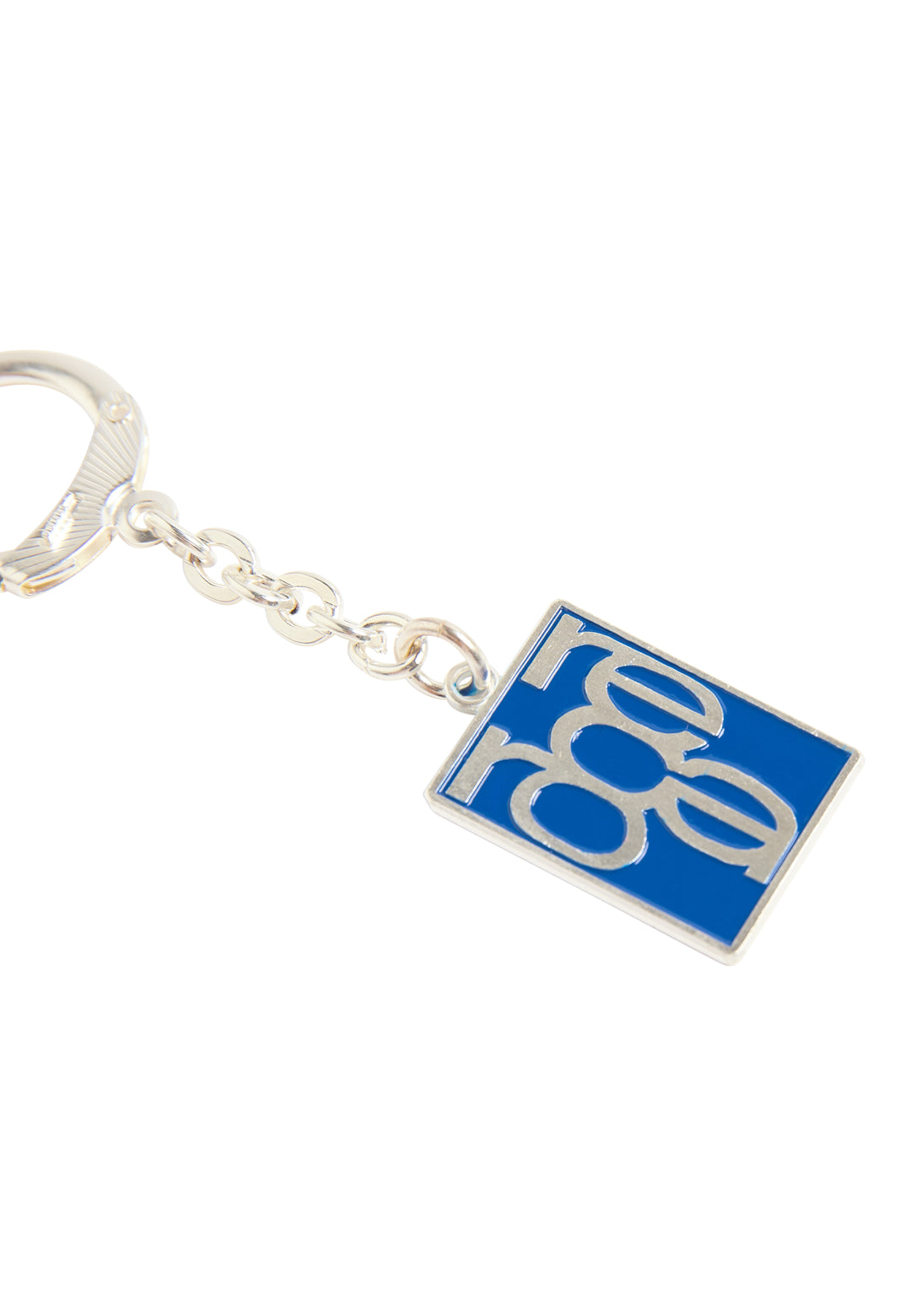 Ein silberner Schlüsselanhänger Retro von Recaro_Merch_Daniel mit quadratischem blauem Anhänger und „rero“ in überlappender silberner Schrift – ein stylisches Accessoire für Fans einzigartigen Designs.
