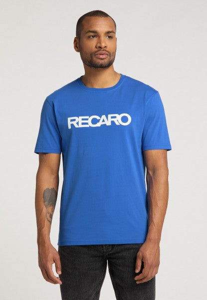 Ein Mann in einem leuchtend blauen T-Shirt mit normaler Passform „Originals RECARO“ von RECARO mit fettem weißen Schriftzug auf der Brust steht vor einem schlichten hellen Hintergrund.