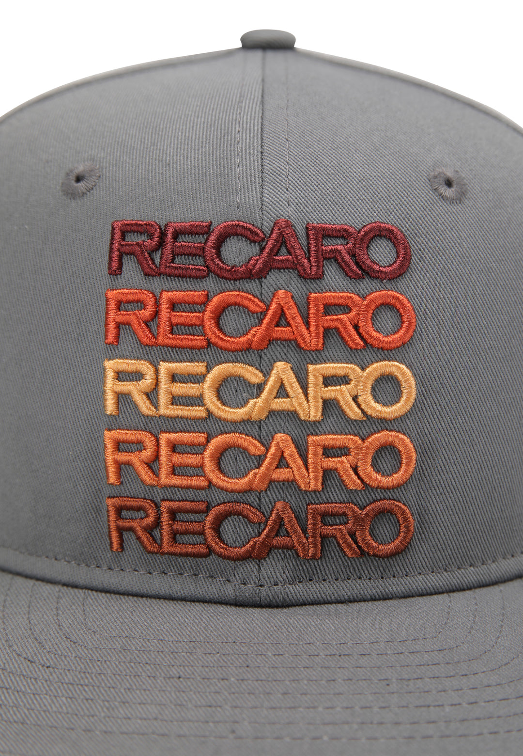Eine Nahaufnahme der RECARO_Merchandising Snapback Cap Spektrum mit dem fünffach gestapelten Schriftzug „RECARO“ im Retro-Stil in den Farben Braun, Orange und Rot.