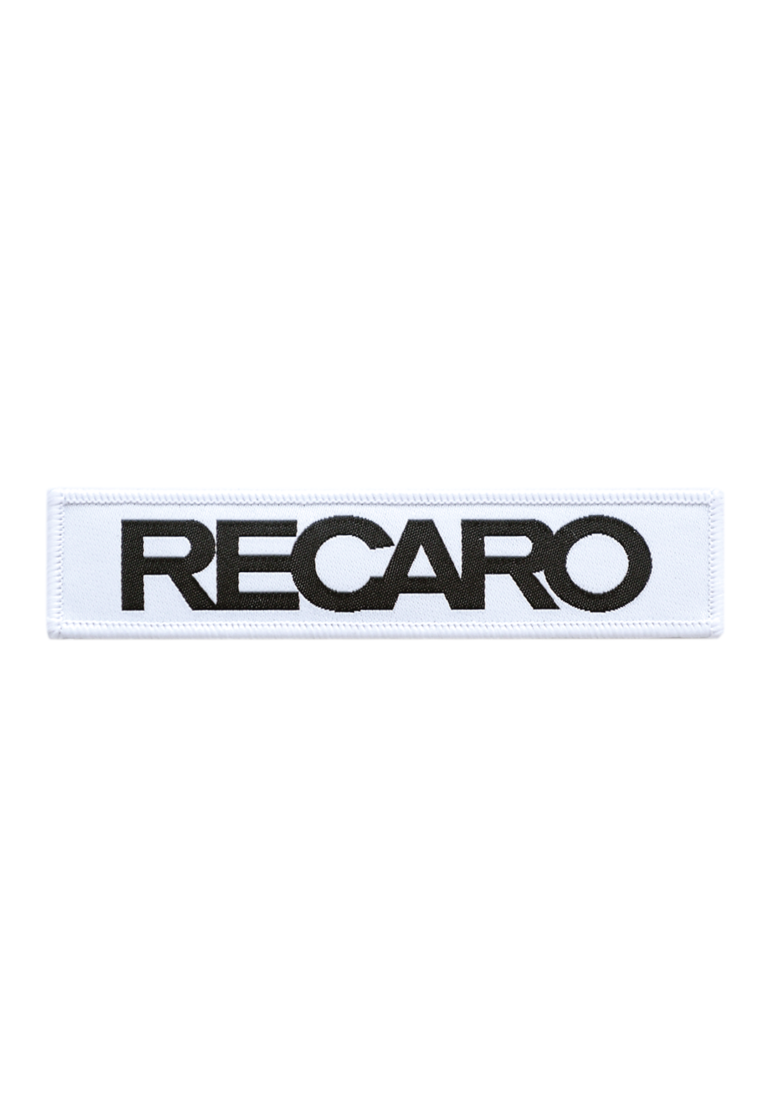 Der Patch RECARO 110x25mm von RECARO ist ein rechteckiger weißer Patch aus strapazierfähigem Material, auf dem mittig das Wort RECARO in fetten schwarzen Großbuchstaben abgebildet ist.