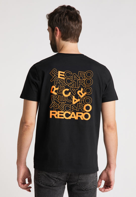 Ein Mann mit kurzen braunen Haaren, von hinten gesehen, trägt das RECARO T-Shirt Backprint mit mehreren überlappenden orangefarbenen RECARO-Logos auf der Rückseite, kombiniert mit dunklen Jeans.