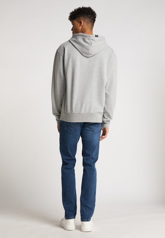 Eine Person steht mit dem Rücken zur Kamera und trägt einen hellgrauen RECARO Hoodie Spektrum, Bluejeans und weiße Turnschuhe vor einem schlichten weißen Hintergrund.