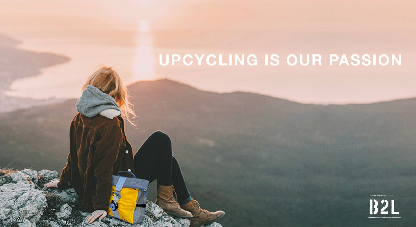Eine Person mit blondem Haar sitzt auf einer Felsklippe und blickt auf einen malerischen Sonnenuntergang oder Sonnenaufgang über Wasser und Hügeln. Daneben steht ein gelb-blauer Rucksack. Der Text lautet „UPCYCLING IST UNSERE LEIDENSCHAFT“ mit einem B2L-Logo am unteren Rand.
