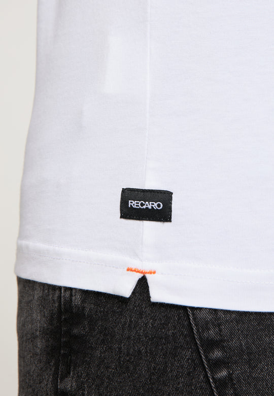 Nahaufnahme des unteren Teils des weißen T-Shirts Originals RECARO von Recaro_Merch_Daniel, Regular-Fit-Baumwolle, mit einem kleinen schwarzen RECARO-Etikett in der Nähe des Saums, getragen über dunkelgrauen Jeans.