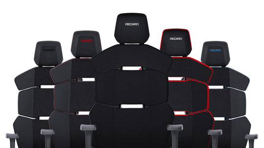 Fünf ergonomische Bürostühle RECARO Nxt aus dem RECARO Shop mit schwarzem Stoff- und PU-Lederbezug sind im Halbkreis angeordnet. Sie bestechen durch verstellbare Kopfstützen, modernes Design und das RECARO Logo auf jeder Kopfstütze.