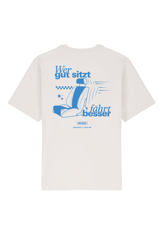 Das RECARO Shop Oversized Shirt WGSFB ist ein cremefarbenes, schweres Baumwollshirt mit einer blauen Autositzgrafik, dem deutschen Satz „Wer gut sitzt fährt besser“ auf der Rückseite, dem RECARO Heritage-Logo und zusätzlichem kleinen Text.