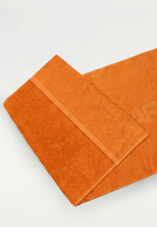 Ein gefaltetes orangefarbenes RECARO XXL-Handtuch aus dem RECARO Shop mit strukturiertem Rand aus 100 % Baumwolle liegt auf einer ebenen Fläche vor einem weißen Hintergrund.