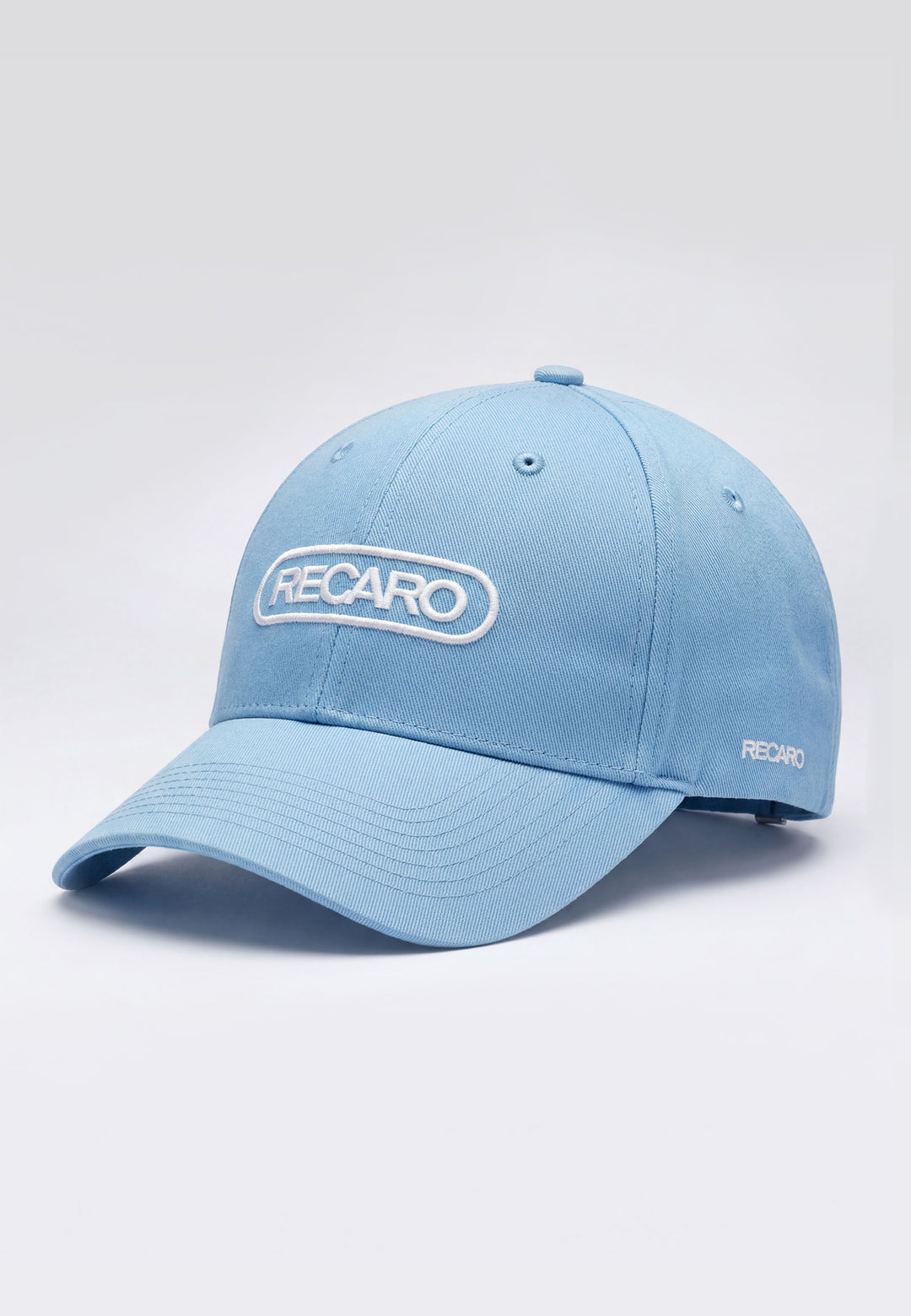 Die Baseball Cap Basic sky von RECARO Shop besteht aus 100% Baumwolle, hat weiße RECARO-Stickereien vorne und seitlich sowie einen verstellbaren Verschluss. Fotografiert auf weißem Hintergrund.