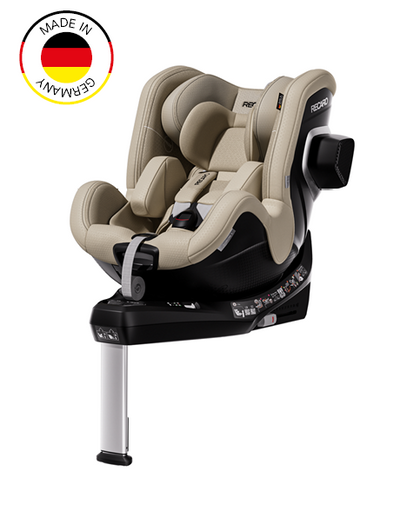 Der RECARO Shop TORON 1 KID ist ein beiger und schwarzer Kindersitz, der mit einem Stützfuß, einem Sicherheitsgurt und Seitenschutz ausgestattet ist. Er verfügt über eine 360°-Drehfunktion für einfachen Einstieg und zusätzlichen Komfort. In der oberen linken Ecke befindet sich ein „Made in Germany“-Emblem mit der deutschen Flagge, das das sichere Design unterstreicht.