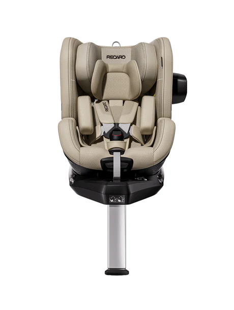 Der RECARO Shop TORON 1 ist ein beiger Kindersitz mit ergonomischem Design, gepolsterten Kopf- und Seitenstützen, Fünf-Punkt-Gurt, verstellbarer Beinstütze und aufrechter Sitzposition auf einer schwarzen Basis.