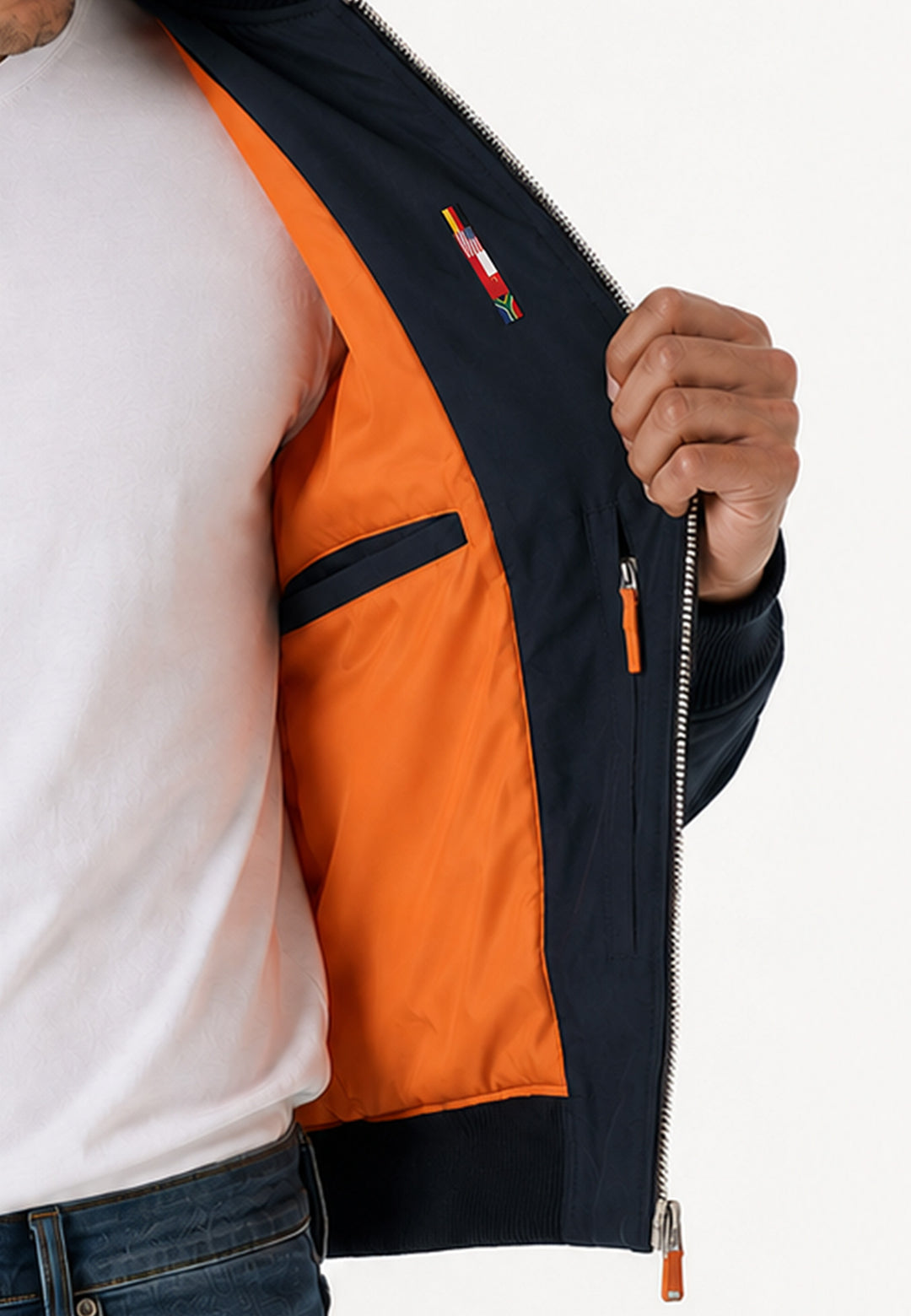 Eine Person in weißem Hemd und Jeans hält die RECARO Shop Pilotenjacke RECARO in navy auf und zeigt ihr leuchtend orangefarbenes Innenfutter und die Innentasche.
