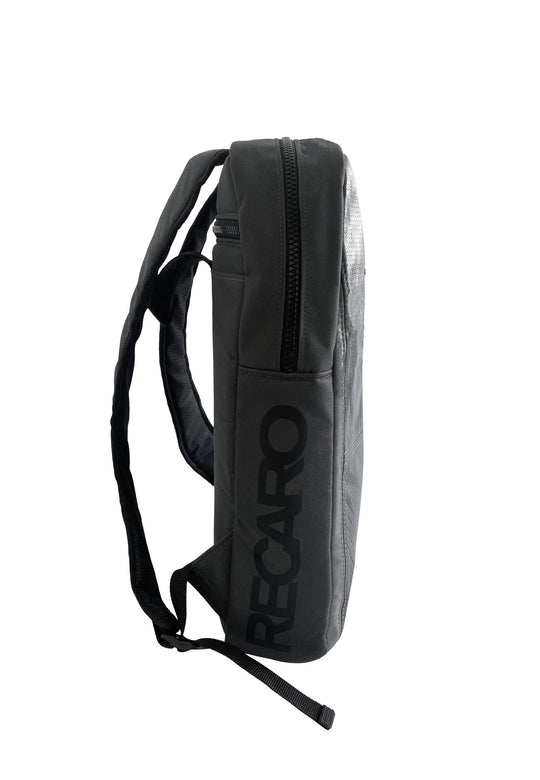 Seitenansicht des RECARO Travel & Tech Rucksacks in Schwarz mit markantem vertikalen RECARO-Logo, Reißverschluss oben, gepolstertem Rücken, verstellbaren Schultergurten und sicherem Laptopfach. Abgebildet vor schlichtem weißem Hintergrund.