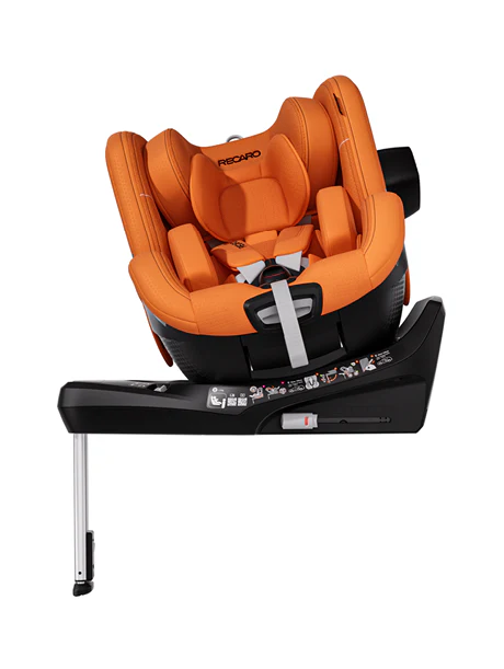 Der orangefarbene Kindersitz TORON 1 aus dem RECARO Shop mit ergonomischem Design steht schräg auf einer schwarzen Basis mit Stützfuß. Er bietet einen Fünf-Punkt-Gurt und eine zusätzliche Polsterung für mehr Sicherheit und Komfort.