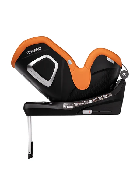 Ein schwarz-orangefarbener TORON 1 KID von RECARO Shop ist in zurückgelehnter Position abgebildet und verfügt über eine Sicherheitsstütze sowie detaillierte Etiketten an der Basis. Dieser Kindersitz ist ab 3 Monaten geeignet und bietet eine praktische 360°-Drehfunktion für müheloses Drehen.