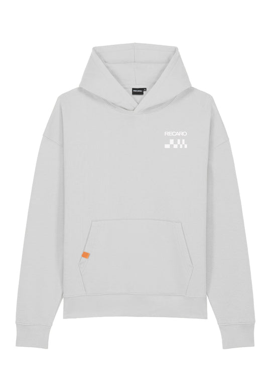 Der RECARO Shop Hoodie RECARO Heavy Cotton ist ein übergroßer, hellgrauer Kapuzenpullover aus ringgesponnener Baumwolle. Er hat eine Vordertasche, ein kleines weißes RECARO Logo und eine karierte Flagge auf der linken oberen Brustseite sowie ein orangefarbenes Etikett an der rechten Tasche.