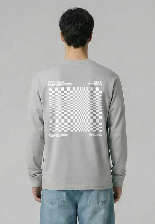 Eine Person, die das RECARO Shop Longsleeve Checkered trägt, ein übergroßes hellgraues Hemd mit einer großen weißen optischen Täuschung in Form eines Schachbretts, Text und RECARO Logo auf dem Rücken, kombiniert mit einer hellblauen Jeans.